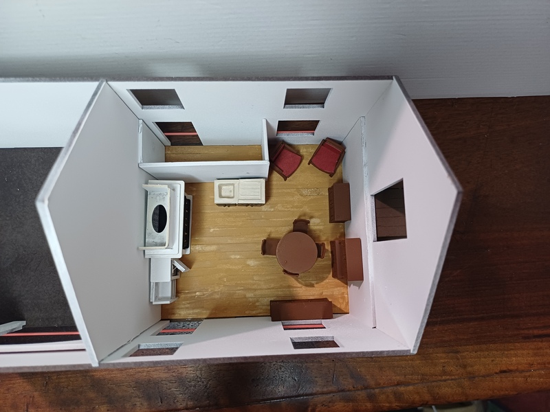 ayant décidé de meubler l'intérieur, je dispose les premiers meubles au rez-de chaussée. la présence d'une porte à l'arrière me laisse imaginer un petit cagibi. la position de la cheminée ne me laisse pas trop de choix pour la position de la cuisinière